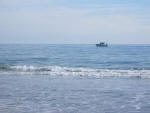 Boat cruises by just off shore.