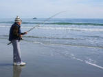 Daddy preparing to cast as a boat cruises by off shore.